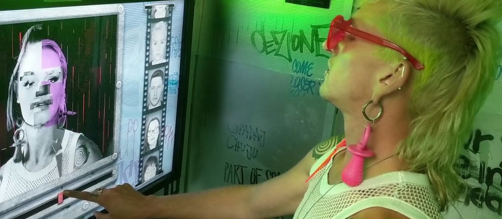 Participant using a touchscreen inside a brightly lit interactive booth.