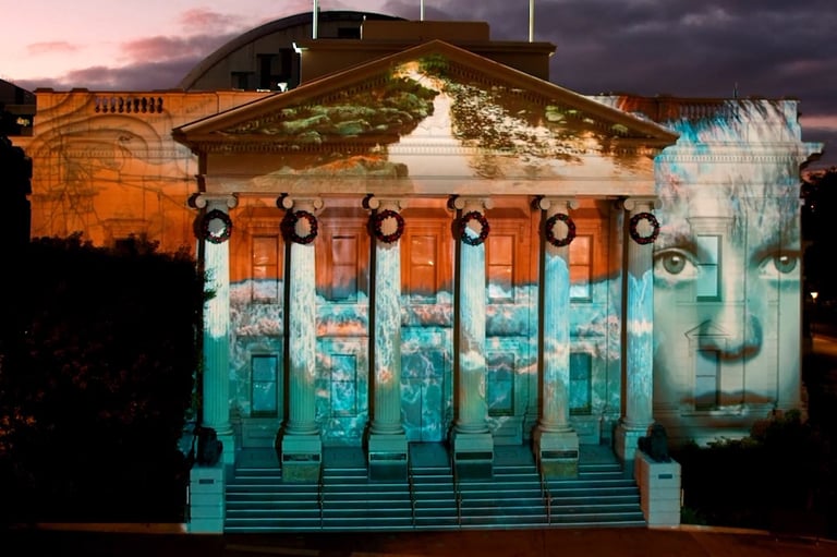 Projection mapping across a civic building’s columns and pediment at night.