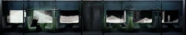Dark theatre set with a row of illuminated rectangular scenes.